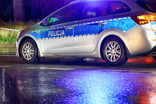 Policja polska radiowóz w akcji na ulicy w ruchu. Policja w deszczu. 