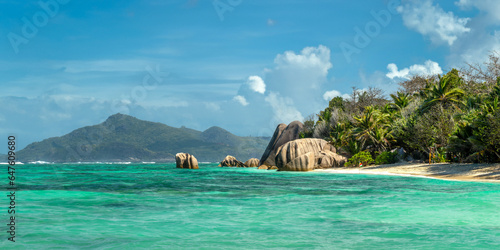 Granite rocks and palm trees on the scenic tropical sandy Anse Source d'Argent beach, La Digue island, Seychelles