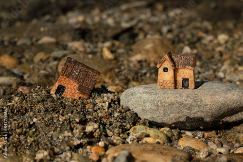 Two miniature houses in sand and on rock (stone). Close-up. Wise and solid foundation gospel parable of Jesus Christ, obedience, and faith in God. Christian biblical concept.