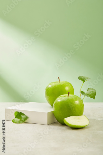 Square-shaped podium with vacant space arranged with organic green apples. Eating Green Apple (Malus domestica) has been shown to improve heart health