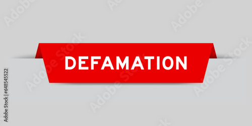 Red color inserted label with word defamation on gray background
