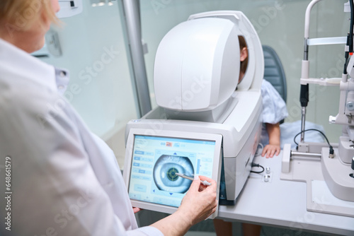 Ophthalmologist taking automated objective refraction measurement in child