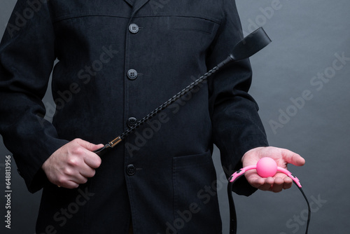 male dominant holds a leather whip Flogger for hard BDSM sex with spanking