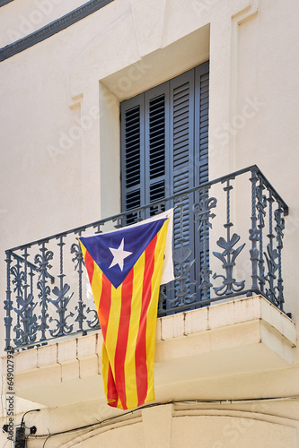 Catalan independence flag hanging from a window demanding the independence of Catalonia