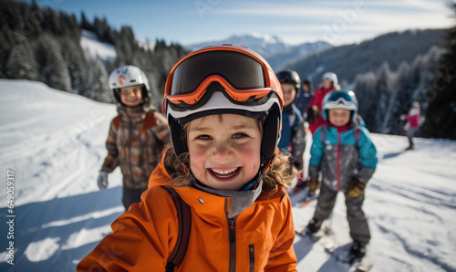 Selfie photo of happy litter girl with ski goggles, skiclothing and helmet, skiing with good friends,