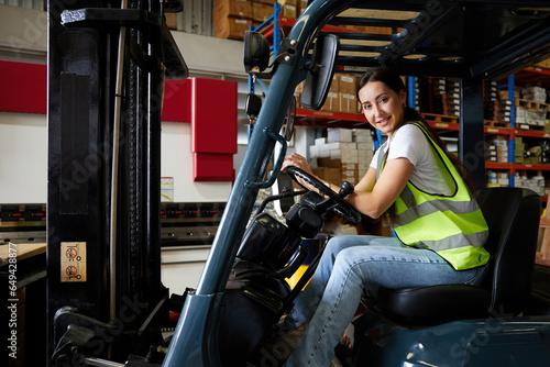 portrait female worker driving a forklift in the warehouse storage