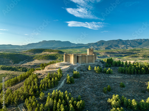 Aerial view of Davalillo castle above the Ebro river in Rioja Spain, with semicircular towers and tower of homage medieval defensive residential building, blue cloudy sky background