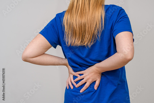 Ból pleców, kobieta trzyma się za dół pleców w okolicach nerek