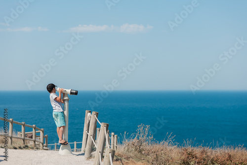 child uses binoculars to observe the ocean