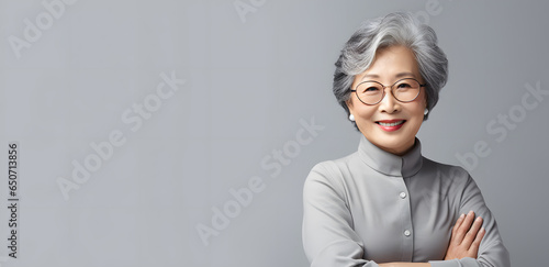 Asian elderly woman in white blouse isolated on light grey background