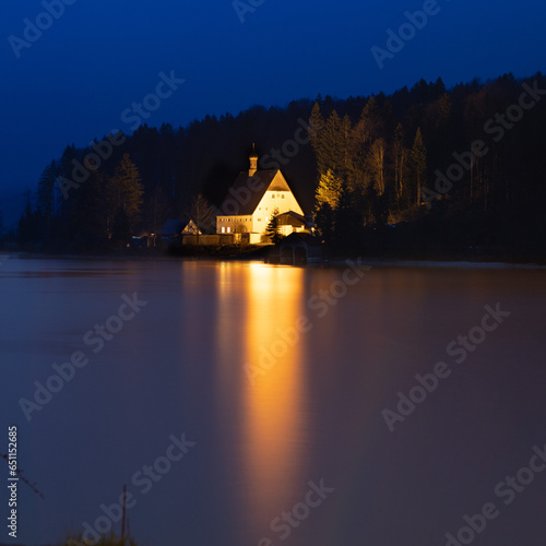 Klösterl am Walchenseeufer spiegelt sich nachts im Wasser