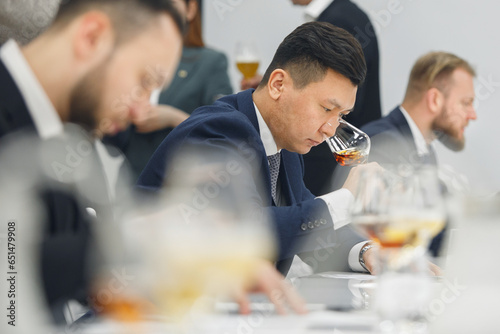 Professional sommelier sniffing unknown whiskey during blind tasting. Sommelier exam to study different wine and whiskey.