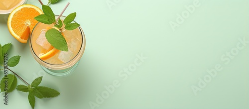 Fresh fruit cocktail in martini glass with ice orange and mint on a isolated pastel background Copy space