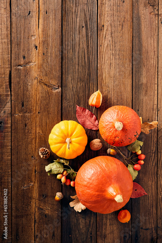 Different pumpkins, fall leaves, acorns, walnuts on wooden table. Happy Thanksgiving day concept.
