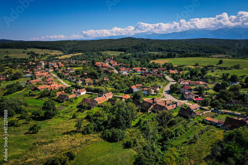Drone photograph of Somartin old saxon village in Transylvania. Fagaras Mountains in the background.