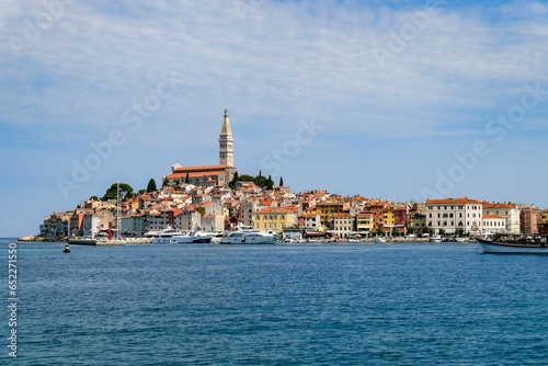 View of Rovinj fishing port with colorful architecture and small ships floating on water, Croatia