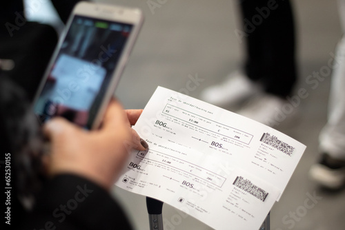 Close-up of a woman using her cell phone to photograph two airline tickets at the airport. Air Transport. Travel concept.