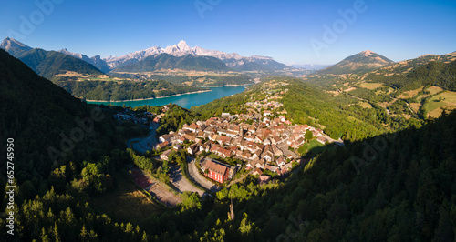 Aerial view of the village of Corps with Sautet Lake. In the distance, the higest point in Devoluy mountain range, the Obiou peak. Isere, Alps, France
