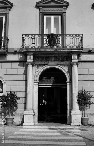 Vertical grayscale of a building entrance with a balcony captured in a street in Moliterno, Italy