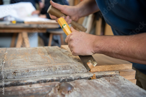 Artisan charpentier réalisant des travaux de restauration sur une ancienne porte