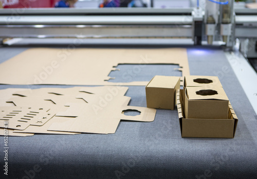 Digital die cut machine cutting corrugated cardboard products. Industrial manufacture.