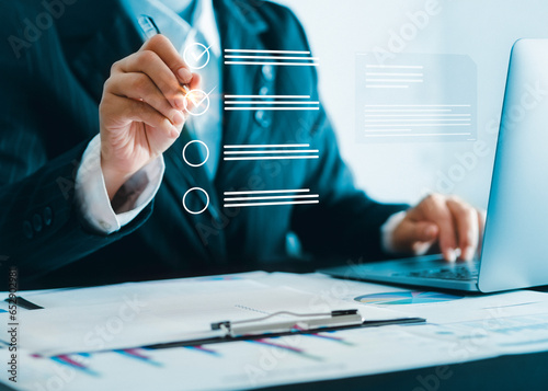 Business performance checklist, businessman using laptop doing online checklist survey, Businessman using pen to tick correct sign mark in checkbox for quality document control checklist..