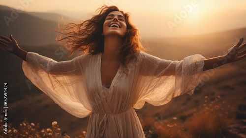 Emotional Liberation: A woman in a peach fuzz color dress stands atop a hill, her arms outstretched, her face radiating joy and freedom