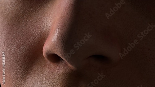 Macro profile of young woman n a black background. Human nose close-up. Human skin. A shadow falls on the face.
