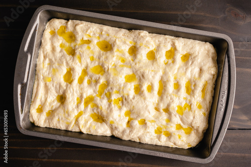 Focaccia Bread Dough Drizzled with Olive Oil: Unbaked Italian peasant bread in a rectangular nonstick baking pan 