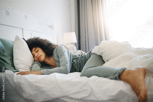 Woman, peace and sleeping on bed in bedroom with fatigue and burnout, dream and relax for stress relief. Exhausted, person and girl in house or home lying on pillow in apartment for wellness and calm