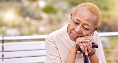 Depression, walking stick and a sad senior woman on a park bench with nostalgia in nature during summer. Face, summer and an elderly person with a disability looking lonely while in the mountains