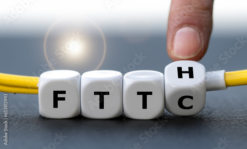 Hand turns dice and changes the expression Fiber to the curb (FTTC) to Fiber to the home (FTTH). Symbol for connecting residences directly with optical fibers.