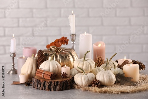 Beautiful composition with pumpkins and burning candles on table