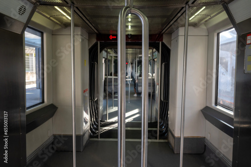 Interior del vagón del metro, donde los pasajeros ocupan los asientos dispuestos a lo largo del compartimento. algunos pasajeros están absortos en la lectura de libros o en sus dispositivos móviles.