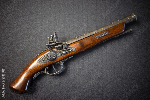 Pirate silicon musket on a black background. Vintage mahogany pistol.A model of an 18th century weapon.