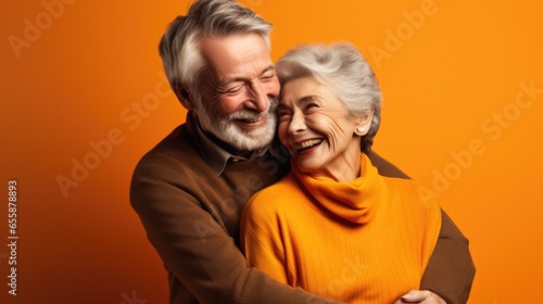 Un couple de personnes âgées, seniors heureux, fond coloré orange