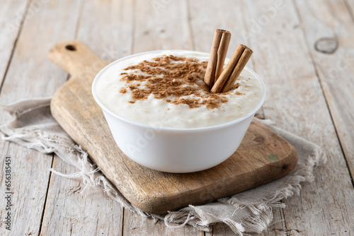 Arroz con leche. Rice pudding with cinnamon in bowl on wooden table.