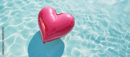 Rose heart buoy floats in the pool seen from above