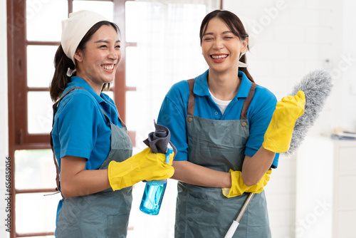 Portrait two Asia woman in workwear maid cleaning home and holding dusting brush and microfiber cloth in her hand at home 