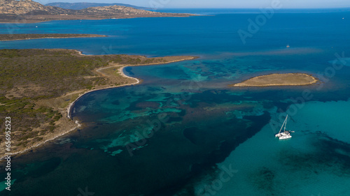 Aerial photo of the island of Isola Piana near Stintino and the beach of Spiaggia La Pelosa. Mountainous island, blue water and clear sky. Northwest part of Sardinia, Sassari Province, Italy.