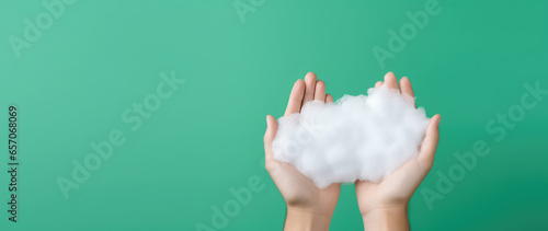 White soap foam in female hands isolated on flat green background with copy space. 