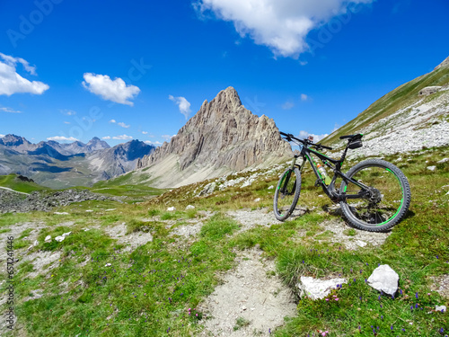 Mountain bike on scenic trail with view of Rocca La Meja near rifugio della Gardetta on Italy French border in Maira valley, Cottian Alps, Piedmont, Italy, Europe. Hiking on sunny summer day in nature