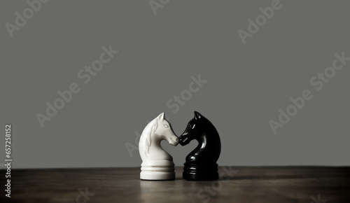 Vintage chess pieces, black and white knight on dark gray background. Chess sports wallpaper. Minimalism. Copy space