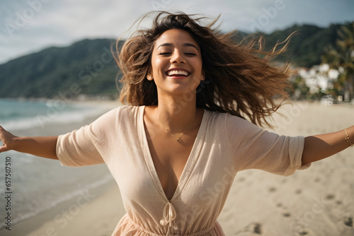 A young woman embraces the beauty of the beach and the freedom . Her arms are outstretched, welcoming the world and all its wonders as she takes a moment to relax and savor the happiness.