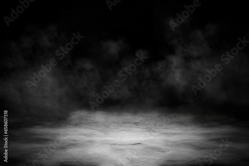 Concrete floor with smoke or fog in dark room with spotlight. Asphalt night street, black background, black and white