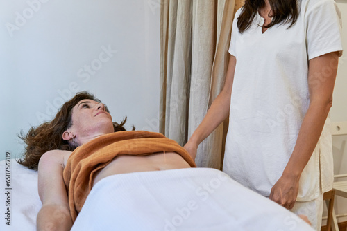 Traditional chinese medicine practitioner and patient talking during acupuncture fertility treatment
