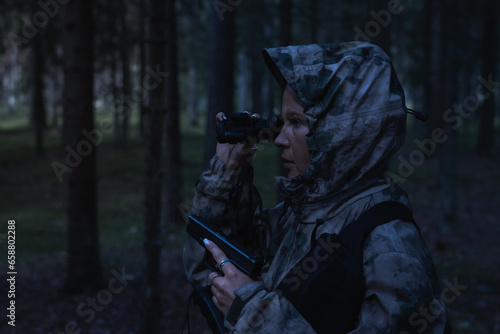 A girl hunting with a night vision device at dusk.