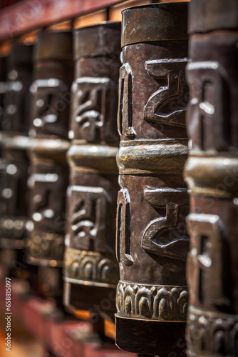 Tibetan Buddhist prayer wheels in Buddhism temple. Shallow depth of field. Rewalsar, HImachal Pradesh, India