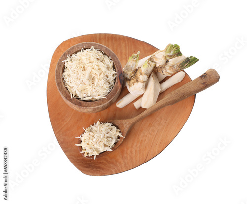 Board with grated horseradish, cut roots and spoon isolated on white, top view