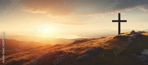 Jesus rising from the dead depicted by cross on a hill at sunrise